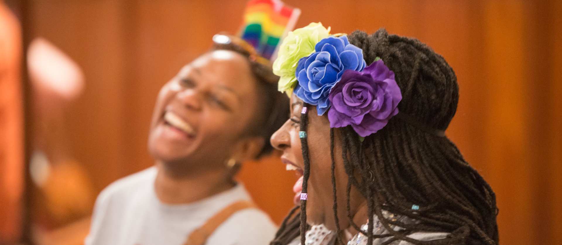 Two people at Pride Worship with rainbow headbands